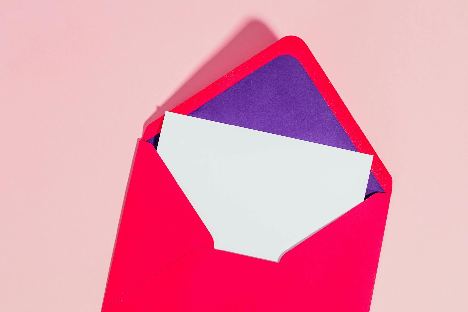 A brightly coloured open envelope with a blank piece of paper inside.